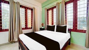 Ein Schlafzimmer mit Bett, Vorhängen und einem Fenster mit Blick.