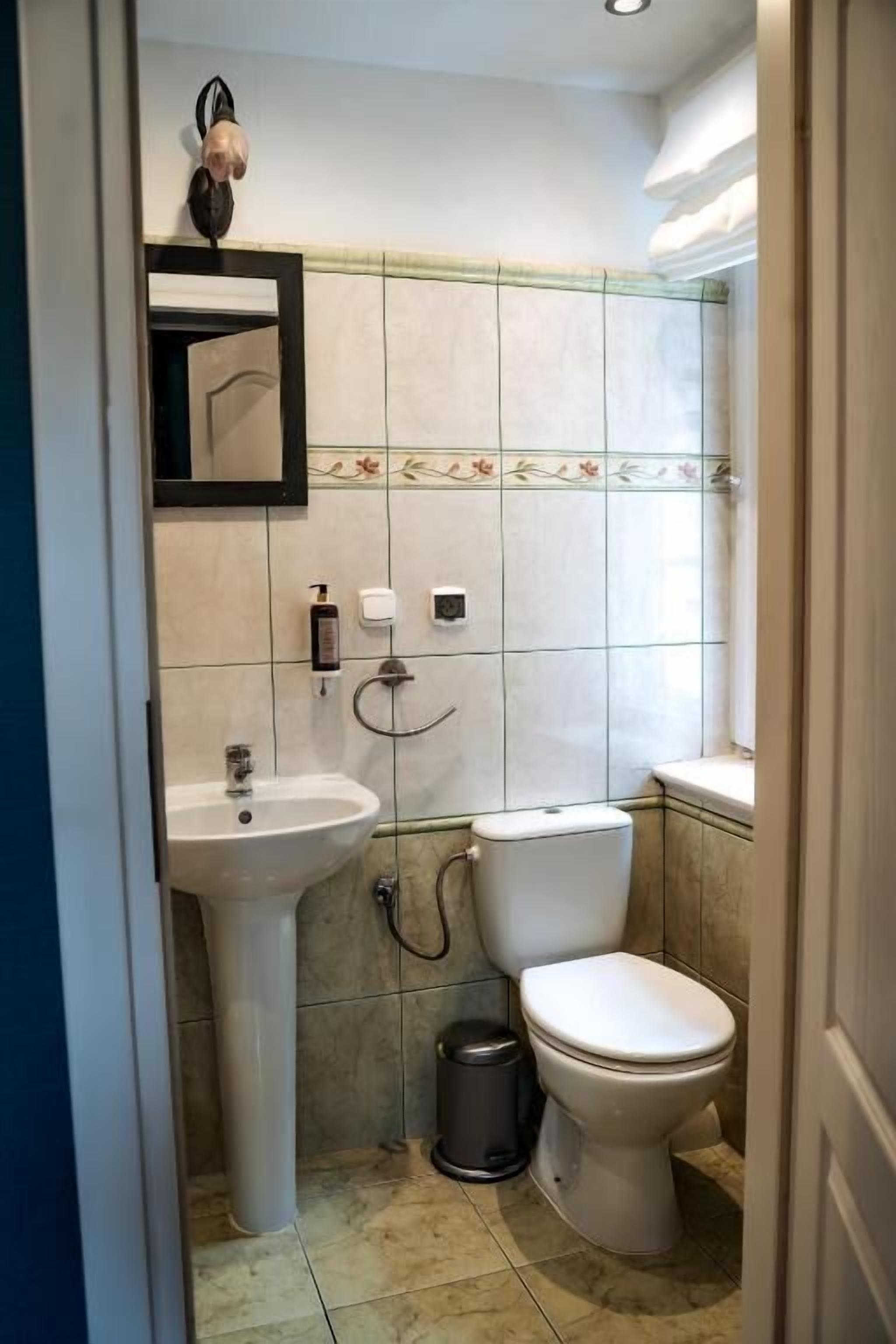 Une salle de bain avec un lavabo, des toilettes et un miroir.