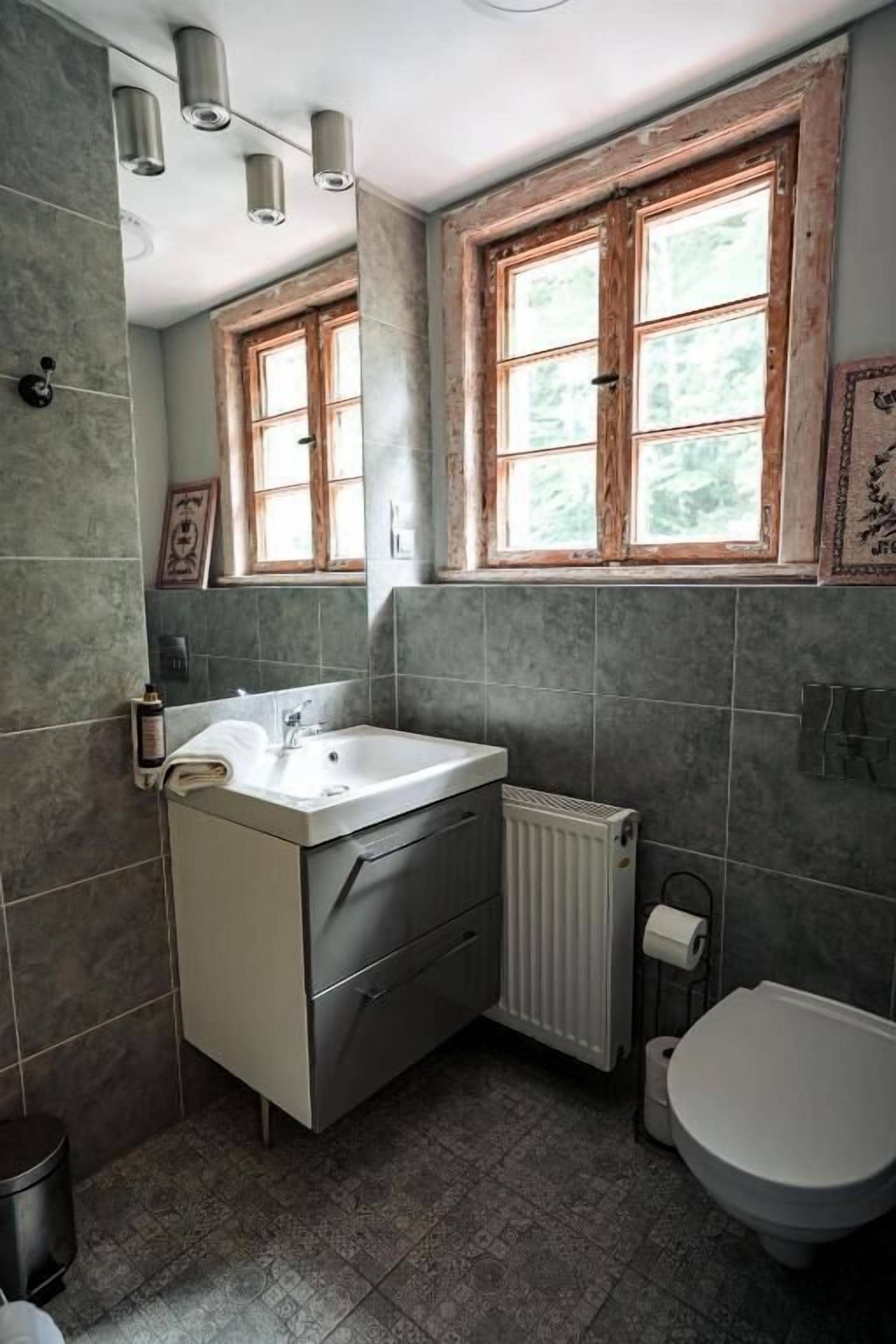 Un bagno con lavandino, WC e finestra.