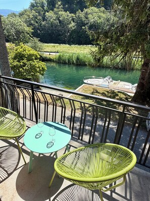 A balcony with two chairs and a table, overlooking a river and greenery. - Les Granges du Canal • Charming accommodation with a view and access to the canal (Vions)