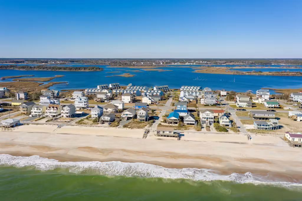 A coastal residential area with houses near the beach and water.