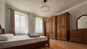 Un dormitorio con cama, armario de madera y espejo.