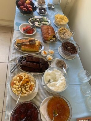 Uma mesa de buffet com diversos alimentos e utensílios.