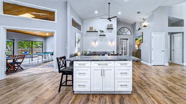 A spacious kitchen with a large island, white cabinetry, and a ceiling fan. - Resort-Style Estate w/ Heated Pool, Theater & Pickleball (Seminole)