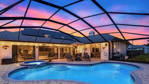 A swimming pool with a covered patio area, a view of the sky, and a building with large windows. - Resort-Style Estate w/ Heated Pool, Theater & Pickleball (Seminole)