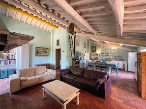 Una sala de estar acogedora con un sofá, una mesa de centro y un comedor con sillas y una mesa.