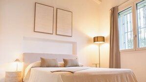 A bedroom with a bed, bedside lamps, a nightstand, a window with curtains, and two wall-mounted picture frames. - Lakefront villa with a private garden and a 4-car garage (Calozzo)