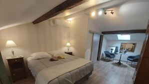 Un dormitorio con cama, mesitas de noche, escritorio y silla.