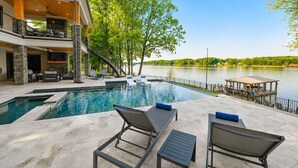 A modern house with a swimming pool, outdoor furniture, and a dock by the lake. - Willow Landing (Troutman)