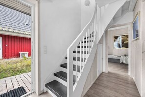 A staircase with white railings and black steps leading to a bedroom with a bed and a window. - "Seeschwalbe" Marina Wendtorf holiday home by the beach with sea view (Wendtorf)