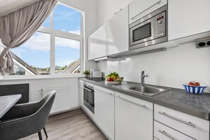 A modern kitchen with a built-in oven, microwave, and sink. - "Seeschwalbe" Marina Wendtorf holiday home by the beach with sea view (Wendtorf)