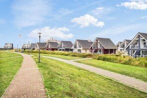 A row of modern, single-story houses with flat roofs and large windows, arranged in a linear fashion along a paved pathway. - "Seeschwalbe" Marina Wendtorf holiday home by the beach with sea view (Wendtorf)
