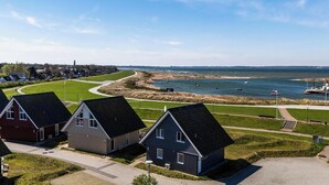 Ein Küstenwohngebiet mit Häusern, einem Fußweg und Blick aufs Meer.