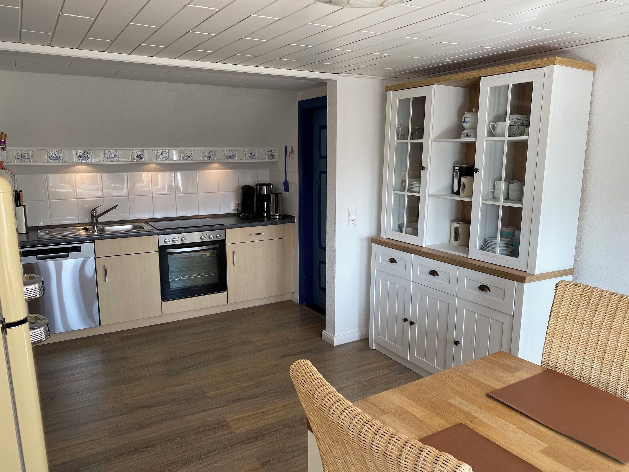 A compact kitchen with a built-in oven, a coffee maker, and a dishwasher.