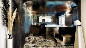 Un bagno moderno con pavimento in pietra, un lavandino e uno specchio.