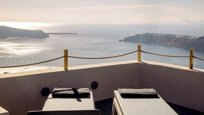 Vista sul mare da un balcone con ringhiera in corda, due sdraio e cielo sereno.