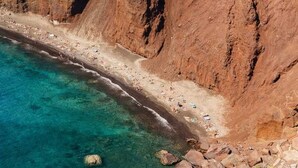 Paesaggio costiero con una scogliera rocciosa e una spiaggia.