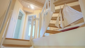 Une maquette de voilier dans une pièce avec des poutres en bois et un plafond blanc.