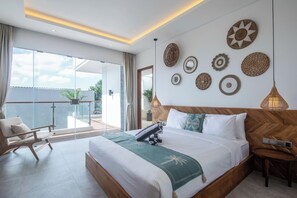 Ett modernt hotellrum med en stor säng, en balkong med en stol och dekorativ väggkonst.