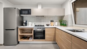 A modern kitchen with a built-in microwave, oven, and coffee maker. - Pedacito de Cielo 1 BDR Sew View apartment & pool (Zagorje)