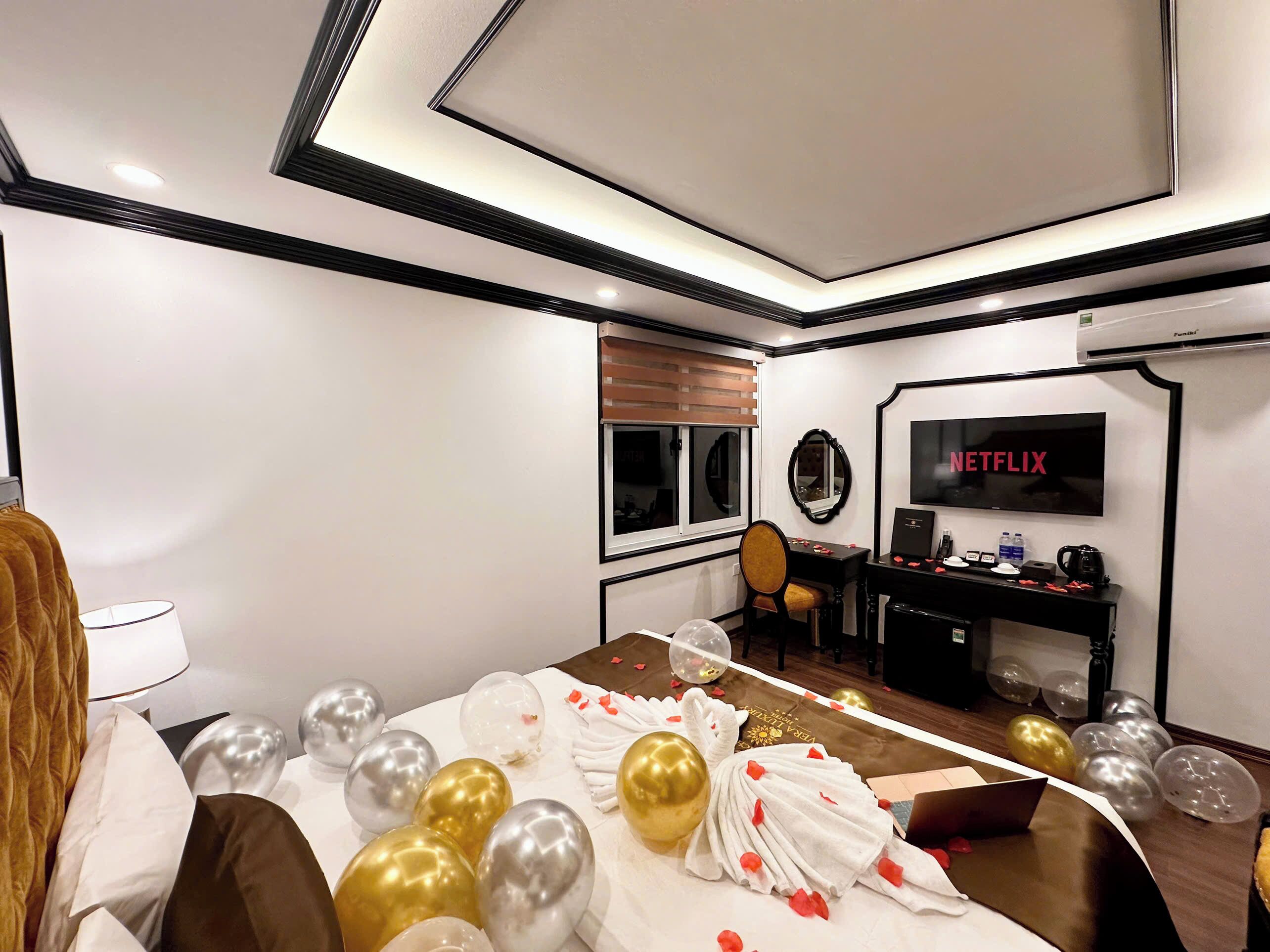 A hotel room with a bed, a desk, a television, and a window.