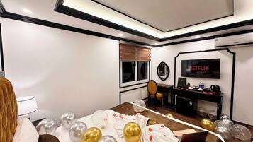 A hotel room with a bed, a desk, a television, and a window.