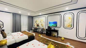 A hotel room with two beds, a television, a desk, and a decorative wall with framed artwork.
