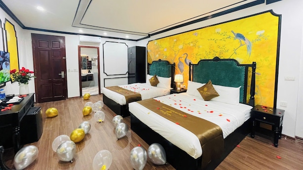 A hotel room with two beds, a mural on the wall, and balloons on the floor. - Vera Luxury Hotel (Hanoi)