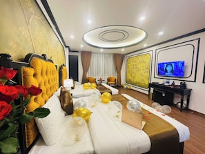 Habitació d'hotel amb un llit, una televisió i un escriptori amb un portàtil.