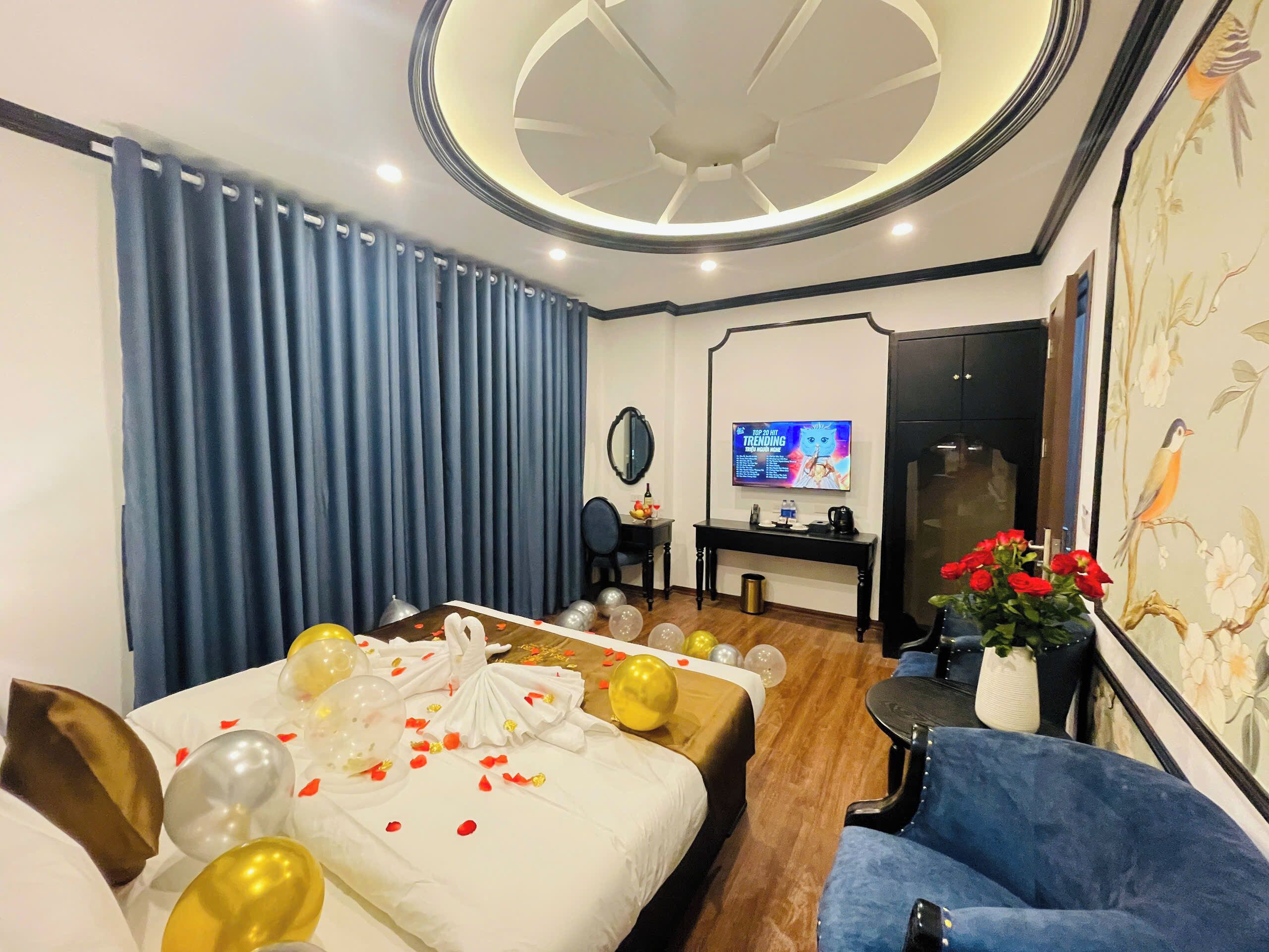 A hotel room with a bed, a desk, a TV, and a blue chair.