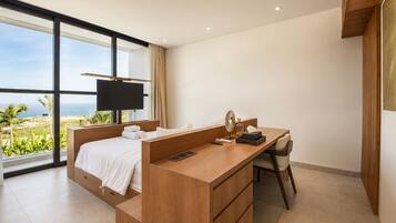 Une chambre d’hôtel moderne dotée d’un grand lit, d’un bureau avec une chaise, d’une télévision et offrant une vue sur l’océan.