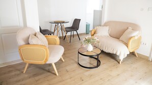 A cozy living room with a sofa, two armchairs, a small round table with a vase, and a dining area with a table and chairs. - Studio apartment Milica  (Kaštel Novi)