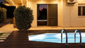 A modern house with a swimming pool, a covered patio, and a large fan mounted on the exterior wall. - Olive Raki Luxury Pool Villa Crete Garden Oasis (Malevizi)