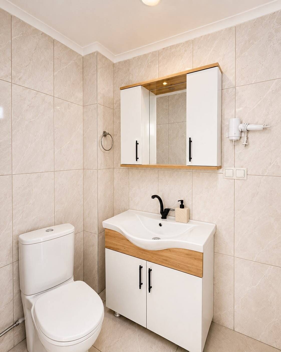 A modern bathroom with a toilet, sink, and mirror.