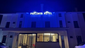 A hotel with a prominent sign reading 'Pavlony Hotel' and a visible entrance with glass doors.