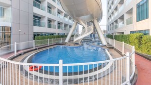 A modern building with a central pool, white railings, and a spiral staircase. - Free Housekeeping Visits During Your Stay - Stayshort - Stunning 2BR in Arjan That Sleeps 4 (Dubai)