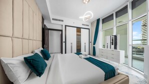 A modern hotel room with a large bed, a wardrobe, a vanity, and a balcony with a view. - Free Housekeeping Visits During Your Stay - Stayshort - Stunning 2BR in Arjan That Sleeps 4 (Dubai)