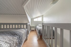 A dormitory room with two beds, a window, and a sloped ceiling. - Moonlight 402 | Private Sauna | Free Parking (Kittilä)