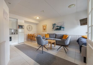A modern living room with a sofa, chairs, a coffee table, and a dining area with chairs and a table. - Levistar 912 | 2BR | Sauna | Steps to Shops & Ski (Kittilä)