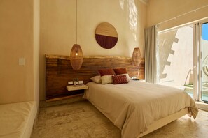 A bedroom with a large bed, a wooden headboard, a round wall decoration, and a view of the outdoors. - Luxury 7BR Villa With Private Pool in Cap Cana (Punta Cana)