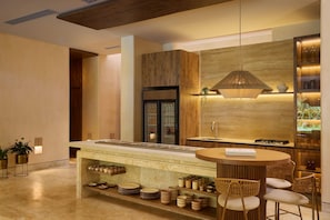 Una cocina moderna con una isla central, armarios de madera y una lámpara colgante.