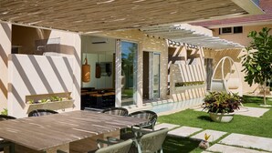 A covered outdoor dining area with a pool, a pergola, and a garden. - Luxury 7BR Villa With Private Pool in Cap Cana (Punta Cana)