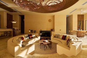 A modern living room with a curved sofa, a coffee table, and a TV.