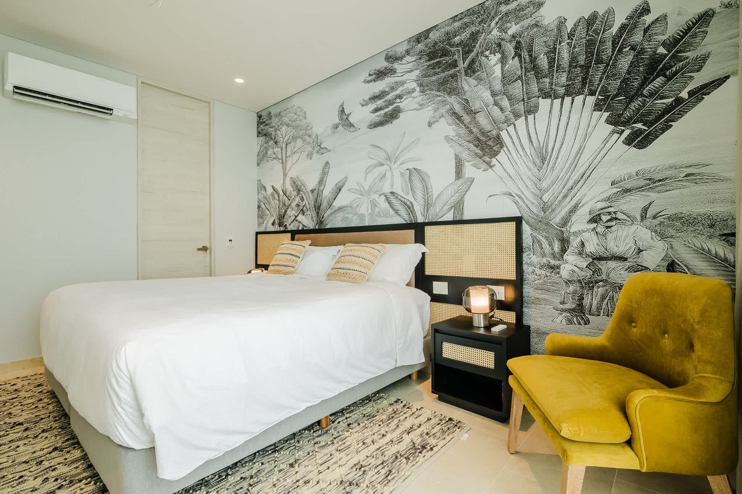 Une chambre à coucher comprenant un lit, une table de chevet, une chaise et une décoration murale.