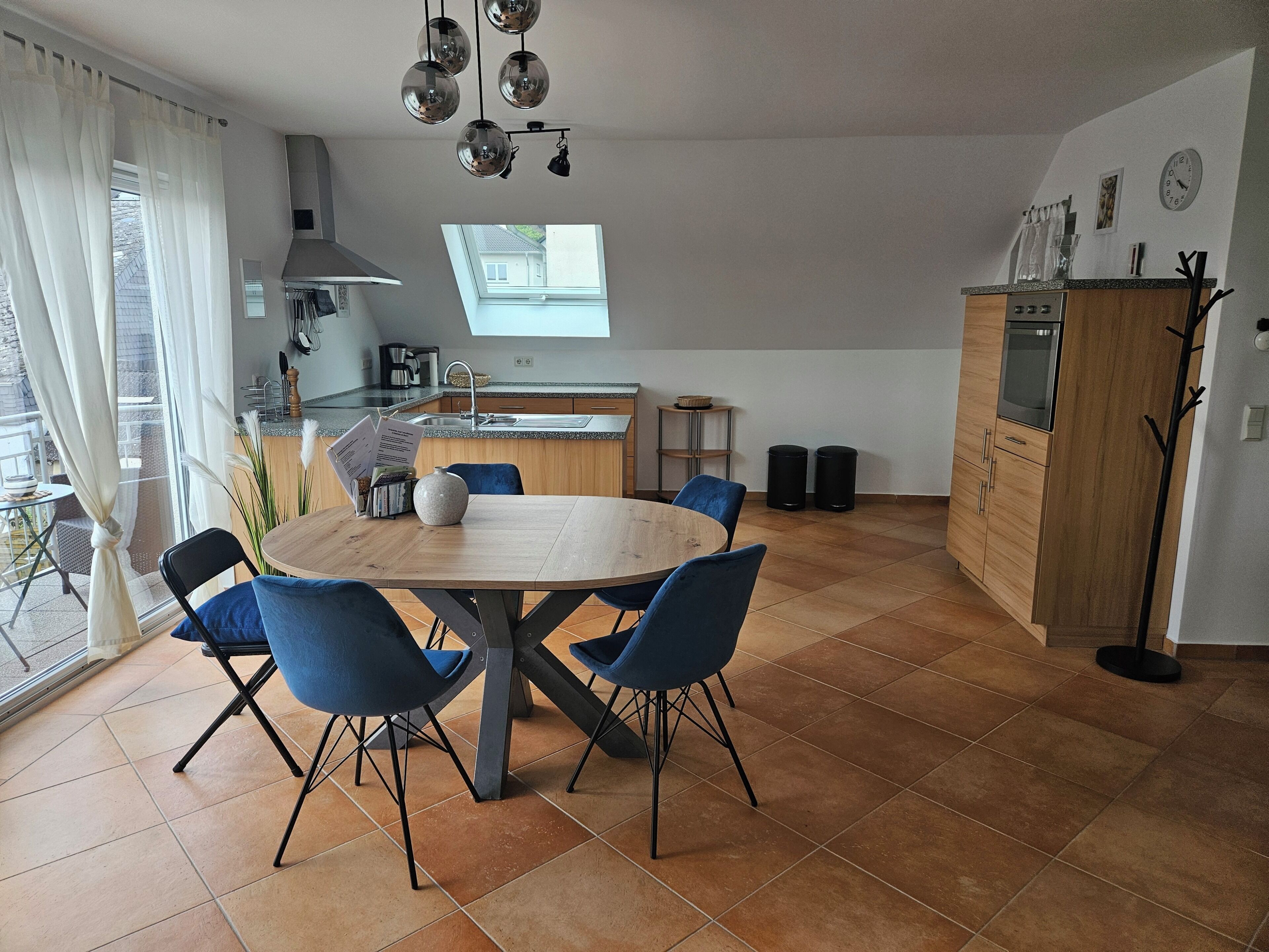 Eine moderne Küche mit Essbereich, einem großen Fenster und Blick ins Freie.