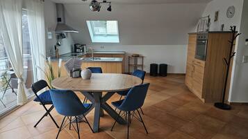 Eine moderne Küche mit Essbereich, einem großen Fenster und Blick ins Freie.