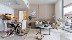 Una sala moderna con comedor, un conjunto de sofá, una mesa de centro y un ventanal grande.