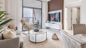 Una sala de estar moderna con un sofá, una mesa de centro y un televisor.