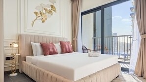A hotel room with a large bed, a balcony with a view, and a decorative wall piece. - The Crest C Luxury Retreat Stylish Serene (Dubai)