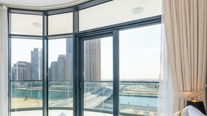 A corner room with a large window, a view of a cityscape, and a balcony. - 1BR Zada Tower l Two Balconies City Views (Dubai)